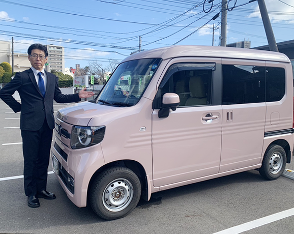 車の横に立つ田中社長の写真